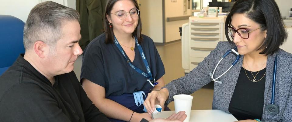 Dr. Rahima Jamal and Camille Amiel prepare the patient to take the fecal microbiota capsules. Photo: Centre hospitalier de l’Université de Montréal (CHUM)